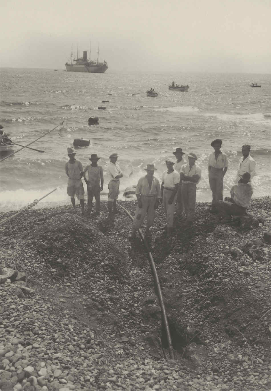 Laying and mooring of the Tenerife-Gran Canaria submarine telephone cable on Regla beach, Santa Cruz de Tenerife. In the background, the cable-laying vessel "S. Dominia".