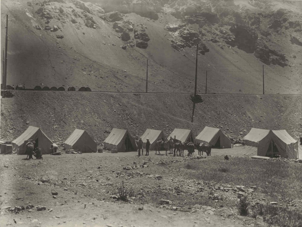 The Transandine Telephone Cable. The camp at Caracoles, Chile. Above can be seen reels of cable ready to be taken by truck and by hand to the new line.

El cable telefónico transandino. El campamento en Caracoles, Chile. Al lado de las líneas férreas pued