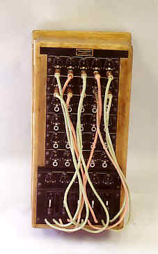 Manual, local battery and magneto telephone switchboard. Equipped with 5 outside lines, 25 inside lines (5 long line circuits and 25 short line circuits) and 5 cord circuits. Model made of wood, consisting of a box with a switchboard system.