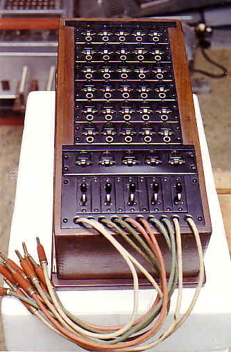 Manual, local battery and magneto telephone switchboard. Equipped with 5 outside lines, 25 inside lines (5 long line circuits and 25 short line circuits) and 5 cord circuits. Model made of wood, consisting of a wooden box with a wooden system....