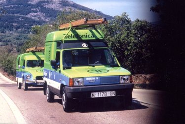 TRANSPORTES : VISTA FRONTAL DE UNA FURGONETA SEAT Y OTRA CITROEN DEL SERVICIO TELEFÓNICO CON SOPORTE PARA ESCALERA, RÓTULO DE TELÉFONOS Y LOGOTIPO DE T DE BOLAS