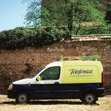 TRANSPORTES : VISTA LATERAL DE UNA FURGONETA SEAT DE DOS PLAZAS DEL SERVICIO TELEFÓNICO CON SOPORTE PARA ESCALERA Y RÓTULO DEL LOGO DE TELEFÓNICA