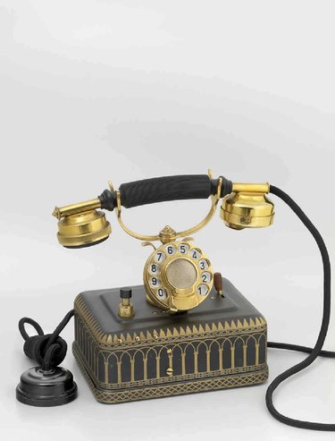 Teléfono automático con conexión a batería central y sonería interior. Este teléfono fue utilizado por el Rey Alfonso XIII entre otras ocasiones, para la inauguración del servicio automático en Madrid, el 29 de diciembe de 1926, así como para la inauguración de la comunicación telefónica España-Cuba en 1928.